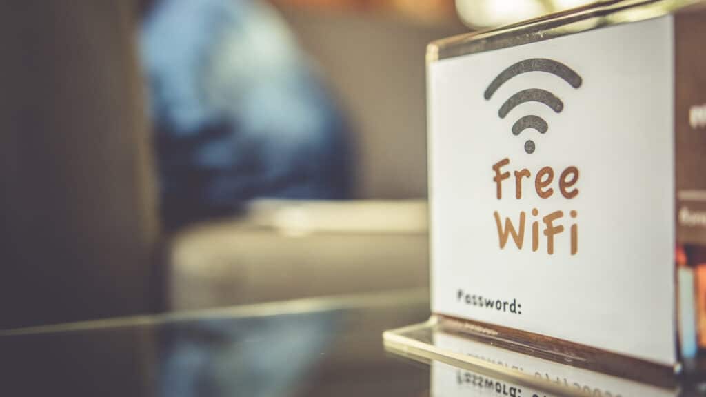 A "Free Wi-Fi / Password:" table tent sign at a café or hotel counter